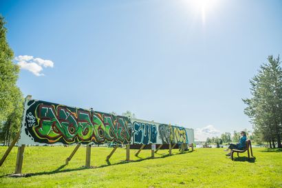 Kuusamon graffitiseinä saa uuden taiteensa hämärän hetkinä – uusittu seinä on entistä pidempi ja tukevampi: "Nuoret kysyivät heti voisivatko olla mukana ideoimassa"