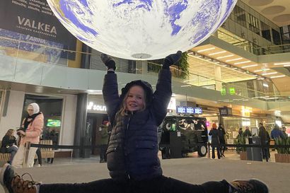Marraskuun lukijakuvassa 10-vuotias Anna Pöyskö pitelee maapalloa hyppysissään